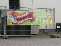 908156 Afbeelding van het spandoek 'Koninklijk afvalscheiden', op een hek rond een tijdelijk inzamelpunt op de Hopakker ...